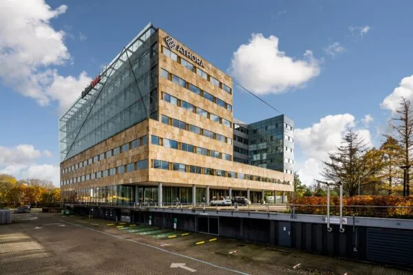 Kantoorgebouw aan de Burgemeester Rijnderslaan met de logo's van Athora en NH Hotel Group.